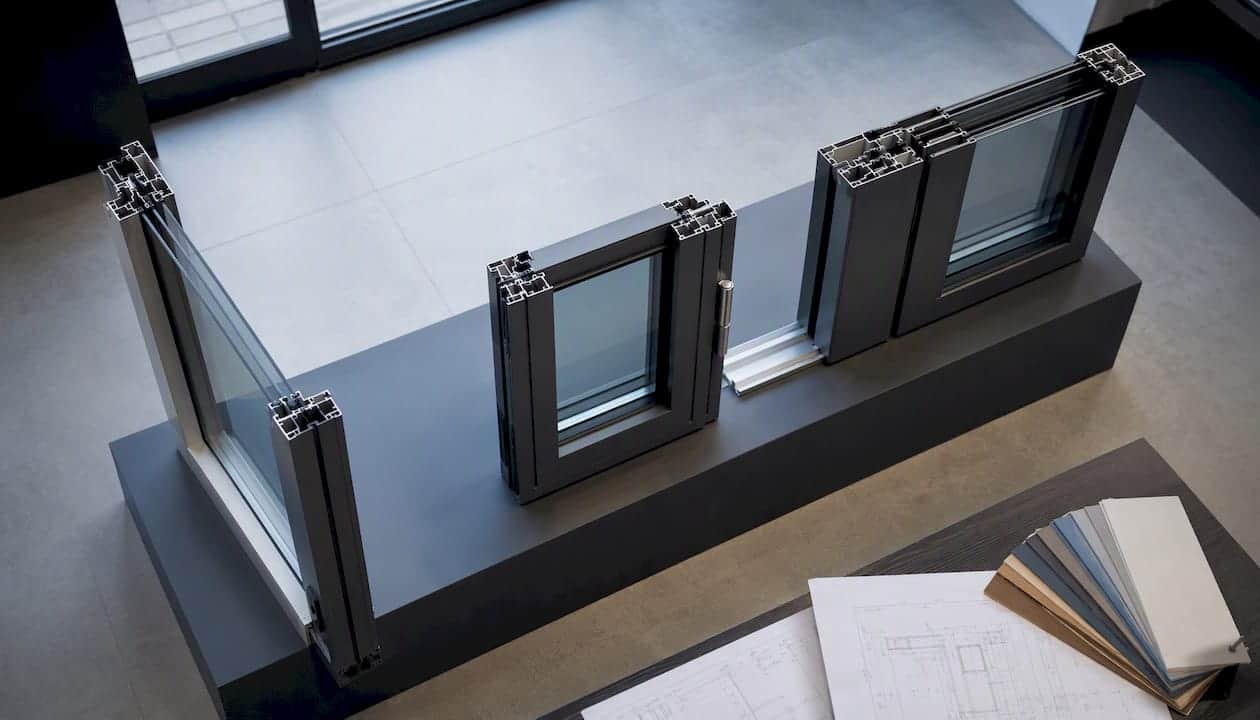 Een selectie van verschillende aluminium profielen voor ramen en deuren wordt getoond.