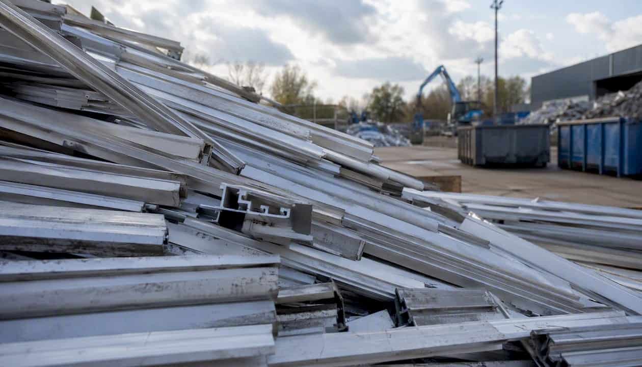 Grote stapels oude aluminium deurprofielen liggen klaar om gerecycled te worden.