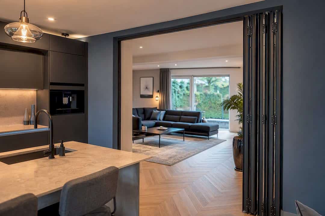 Opengeklapte aluminium vouwdeur tussen keuken en woonkamer