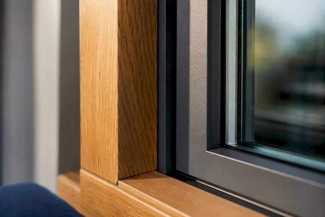 De aansluiting tussen hout, aluminium en glas