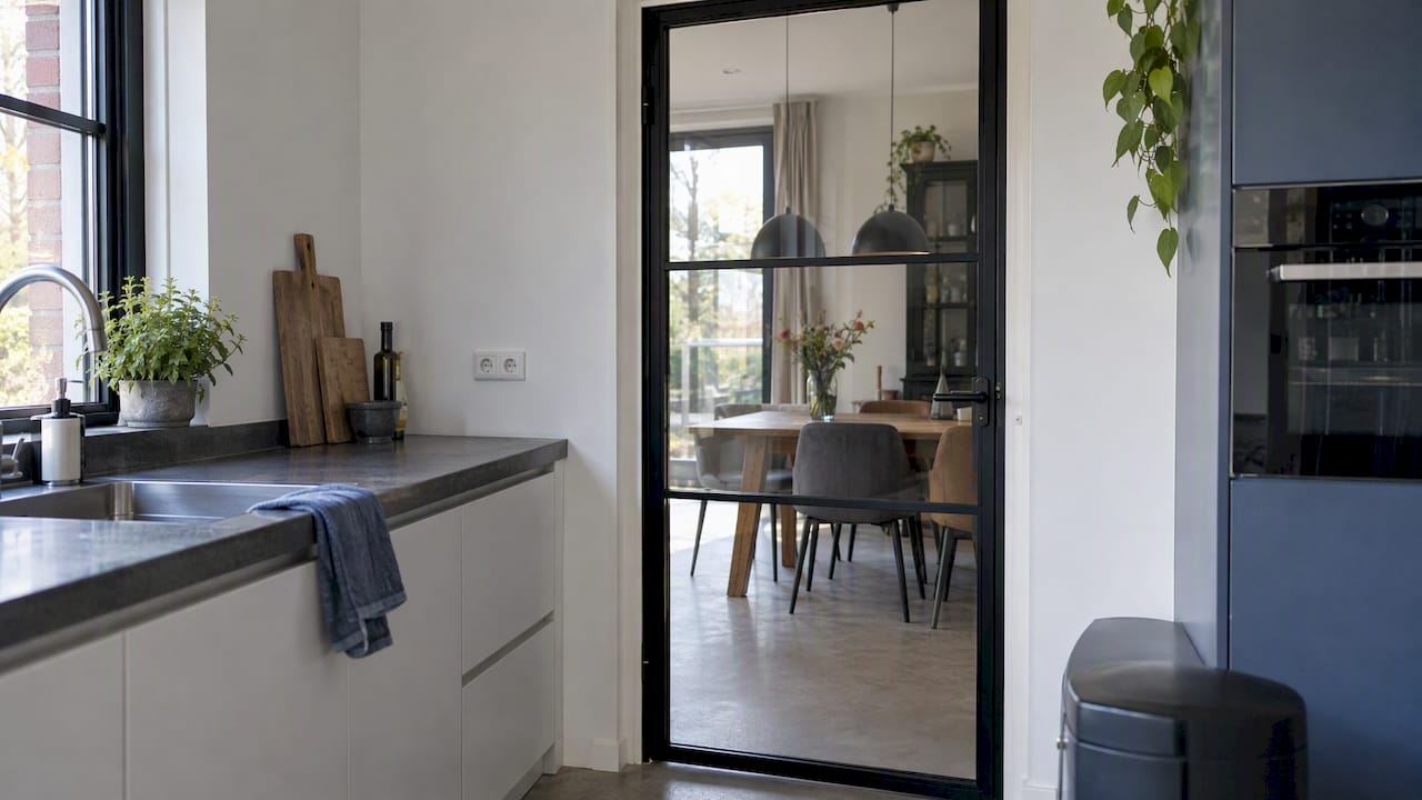 Stalen look glazen deur tussen keuken en eetkamer